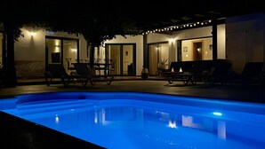 An outdoor pool area with lounge chairs and a barbecue setup. - Aloe Villa - Spacious and luminous villa with heated pool -Fiber (La Oliva)