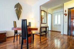 A dining area with a wooden table, chairs, and a wall-mounted sculpture.