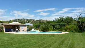 A swimming pool with lounge chairs and umbrellas, surrounded by a well-maintained lawn and trees. - 4 Bed Idyllic Fayence Retreat Private Pool Great Views (Fayence)