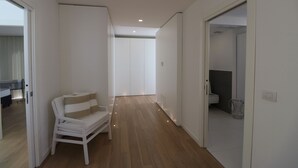 A hallway with a white sofa, a door leading to a bathroom, and a ceiling light. - Deluxe Villa with private pool and jacuzzi 2km from Ortigia, Sicily (Siracusa)