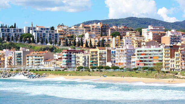 Paisagem costeira urbana com praia e edifícios bem próximos.