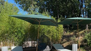 A swimming pool with lounge chairs and umbrellas, surrounded by trees and a wooden deck. - 5 bedroom VILLA with pool on a hillside near AIX  (Mimet)