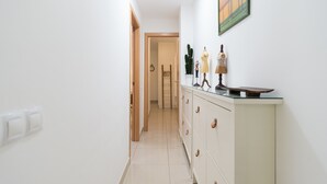 A hallway with a white cabinet, a door, and a wall-mounted picture.