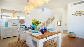 A dining area with a wooden table, white chairs, and blue tableware.