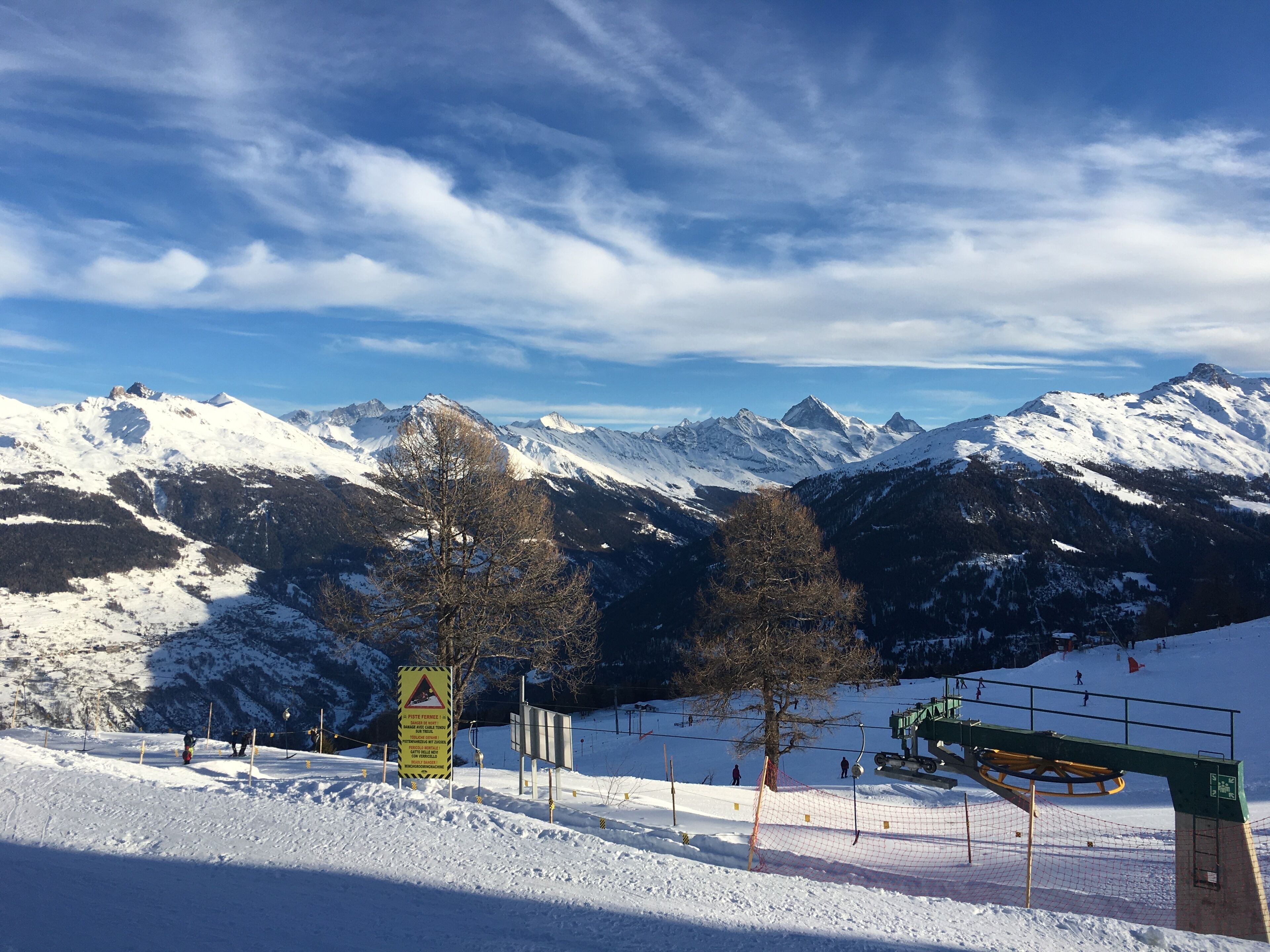 Eine verschneite Berglandschaft mit Skipisten und einer Seilbahn.