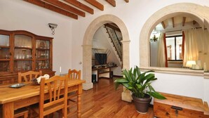 Ein Essbereich mit Holztisch und Stühlen, einem Schrank mit Glastüren und einer Treppe, die in eine andere Ebene führt.