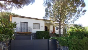 A two-story house with a stone wall and a black gate. - Palenque CostaBravaSi - Pool, BBQ, garden, Golf (Santa Cristina d'Aro)