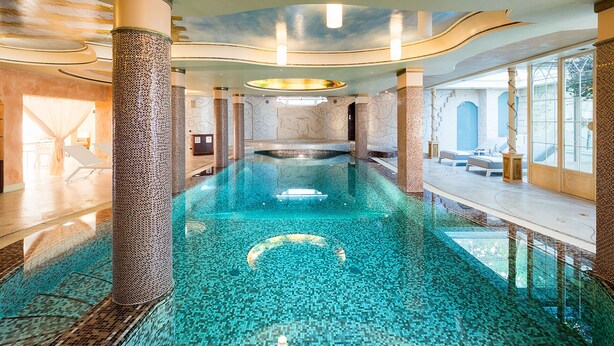 A large indoor swimming pool with clear blue water, surrounded by columns and a modern architectural design. - Luxury villa with heated pool and wellness area, 1,5 km away from sea, Donnalucata   - Villa Drago Spa (Scicli)