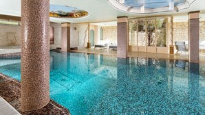 An indoor swimming pool with clear blue water, surrounded by stone walls and columns. - Luxury villa with heated pool and wellness area, 1,5 km away from sea, Donnalucata   - Villa Drago Spa (Scicli)