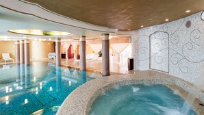 A large indoor pool area with a hot tub, lounge chairs, and a seating area with a red chair. - Luxury villa with heated pool and wellness area, 1,5 km away from sea, Donnalucata   - Villa Drago Spa (Scicli)