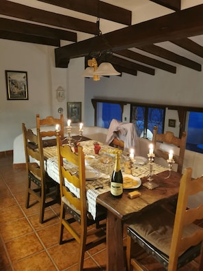 A dining area with a wooden table set for four, candles, and a bottle of champagne. - Fantastic sea views, charming villa, heated pool. (Salobreña)