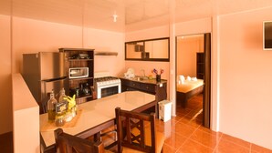 Una cocina moderna con una isla central, electrodomésticos de acero inoxidable y un comedor con sillas de madera.