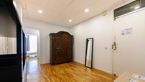 Habitación con piso de madera, un armario amplio, una puerta con espejo y una pared blanca con el símbolo de WiFi.