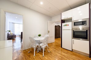 Eine moderne Küche mit weißen Schränken, einem Backofen und einer Mikrowelle.