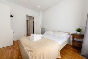 A hotel room with a bed, a bedside table with a plant, and a radiator. - Luxury apartment Centro Madrid Downtown M (VEL55) (Madrid)