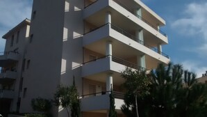 A multi-story building with balconies and a clear sky. - T1 standing entrance of CALVI  (Calvi)