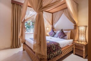 Relax in a serene space with a four-poster canopy bed and a view of lush greenery.