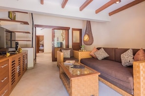 Relax in this stylish living room with a high ceiling, sofa, coffee table, and TV.