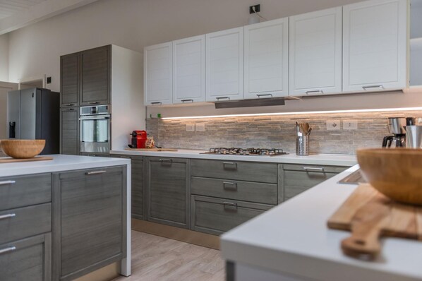Enjoy cooking in this well-equipped kitchen with a central island, ample counter space, and modern appliances.