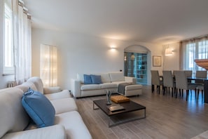 Relax in this stylish living room with a sofa, coffee table, and dining area.