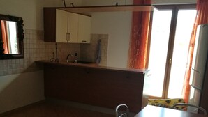 A kitchen with a tiled floor, a sink, a countertop, and a window with curtains. - Casa D Annunzio weekly discount + wi-fi (Pescara)