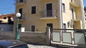 A multi-story residential building with balconies, a gated entrance, and a street lamp. - Casa D Annunzio weekly discount + wi-fi (Pescara)