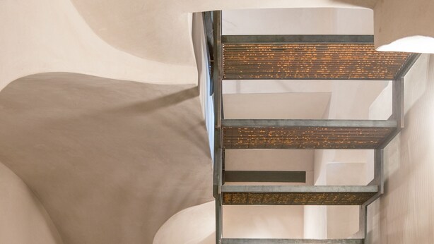 Ein modernes Interieur mit Wendeltreppe, minimalistischem Badezimmer und einer Dekoration aus einem Ast.
