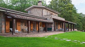 A stone building with a covered patio and outdoor seating. - La Dimora di Teresa: fairytale house in the woods, ideal for families with children. (Sovicille)