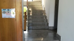 Una escalera con una puerta de madera a la izquierda y un letrero en ella.