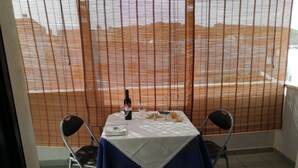 Un comedor con una mesa dispuesta para dos personas, una botella de vino y un objeto decorativo sobre la mesa.