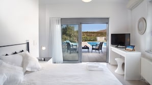 Une chambre avec un lit, une télévision, un bureau et une vue sur une piscine et des montagnes.