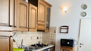 A kitchen with wooden cabinets, a stove, a sink, and a microwave. - Andrea's House. Cls to all amenities. (Firenze)