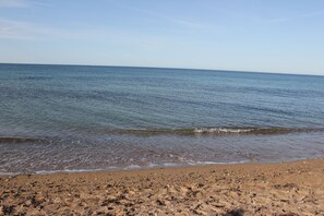 Une plage où l’eau est calme et le ciel est dégagé.