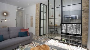 A modern living room with a grey sofa, a coffee table, and a TV on a stand. - Singular Stays Parque Central IX (Valencia)