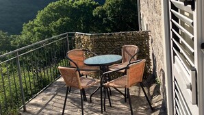 A balcony with wicker furniture and a view of a mountainous landscape. -  Hillside apartment with stunning views of sea and mountains, sea 2 km, pool (Tivat)