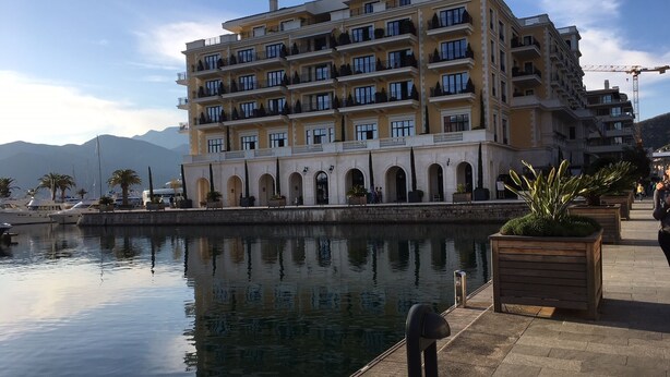 A multi-story hotel with balconies, a waterfront view, and a stone facade. -  Hillside apartment with stunning views of sea and mountains, sea 2 km, pool (Tivat)