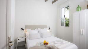 A bedroom with a bed, bedside table, and a window. - Singular Stays Parque Central III (Valencia)