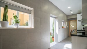 A modern kitchen with a window, potted plants, and a view of the outside. - The Dreams House with Green Patio (Lisboa)