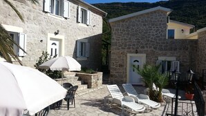 A stone building with a terrace, outdoor seating, and a view of the hills. - Magnificent Views, Large private terrace overlooking mountains, pool, sea 2km (Tivat)