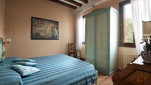 A bedroom with a bed, a wardrobe, a painting, and a window with curtains. - Elegant apartment with garden in S.Croce, Venice (Santa Croce)