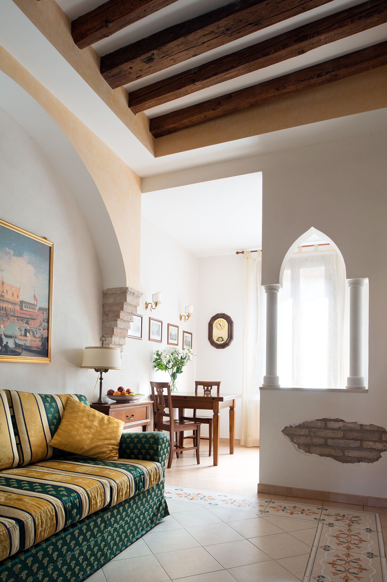 A cozy living room with a sofa, a dining table, and a kitchen area.