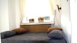 Un letto con testiera, cuscini e una finestra con tende.
