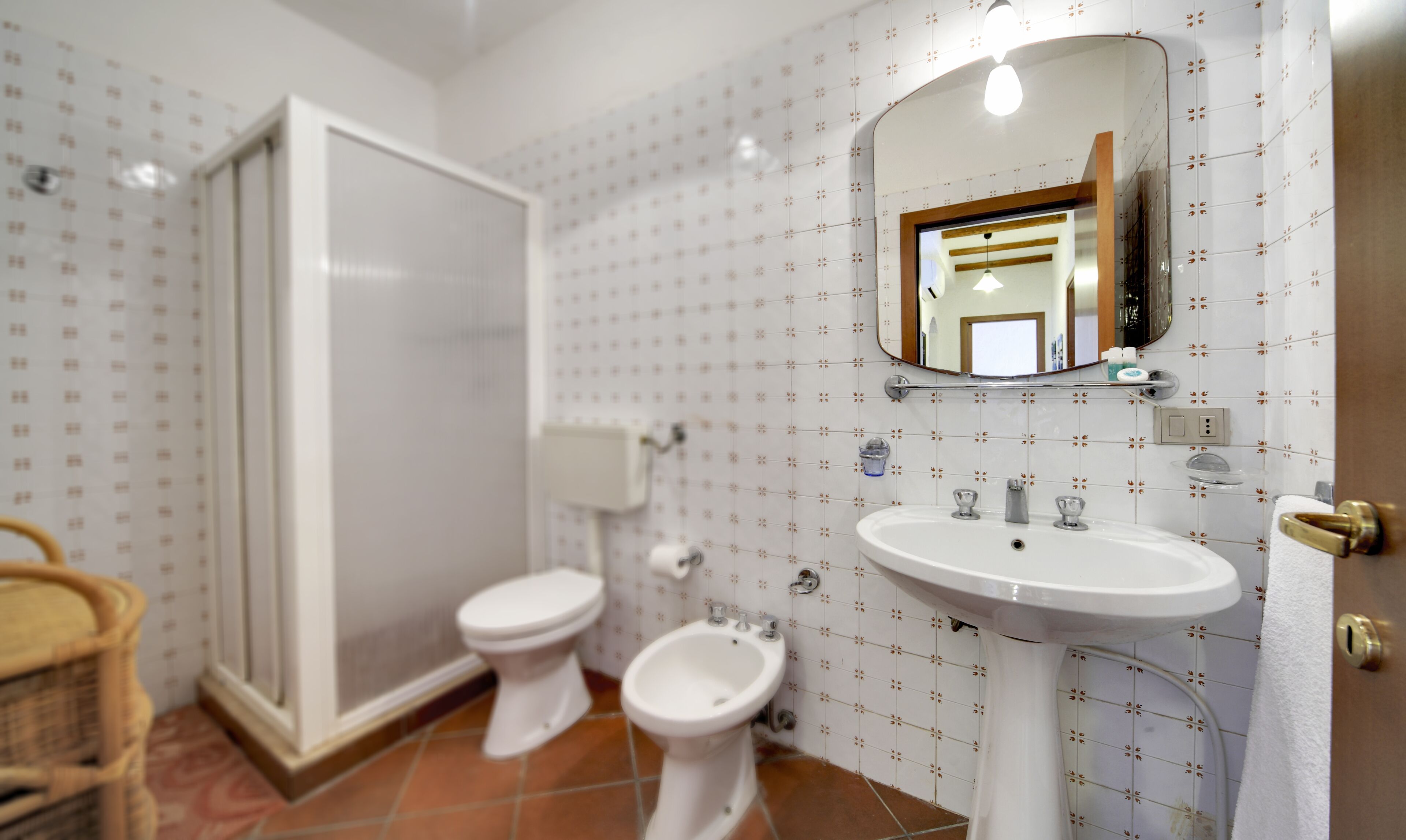A bathroom with a toilet, bidet, and sink.