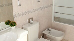 A bathroom with a toilet, bidet, and sink.