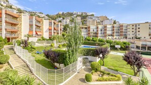 A residential area with apartment buildings, a swimming pool, and a tennis court.