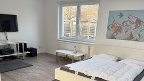 Un dormitorio moderno con una cama, un escritorio y una ventana.