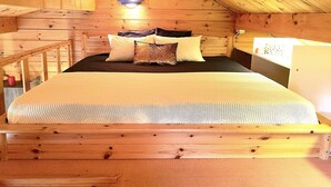 A wooden cabin bedroom with a bed, pillows, and a nightstand. - House with garden in the center of Berlin for up to 3 people (Berlin)