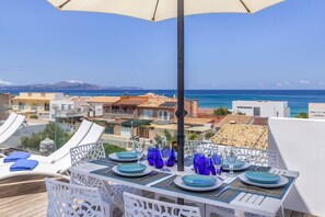 A terrace with tables set for dining, overlooking a coastal town and the sea. - Sunny House With Sea Views in Son Serra, Mallorca (Son Serra de Marina)