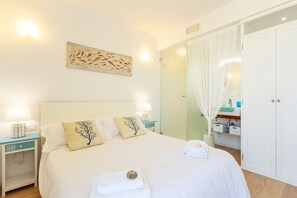 A hotel room with a bed, nightstands, a vanity with a mirror, and a wardrobe. - Sunny House With Sea Views in Son Serra, Mallorca (Son Serra de Marina)