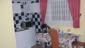 A compact kitchen with a microwave, coffee maker, and a small table with chairs. - Small apartment central location Fulda Rhön Vogelsberg Hesse 2 pers. (Künzell)